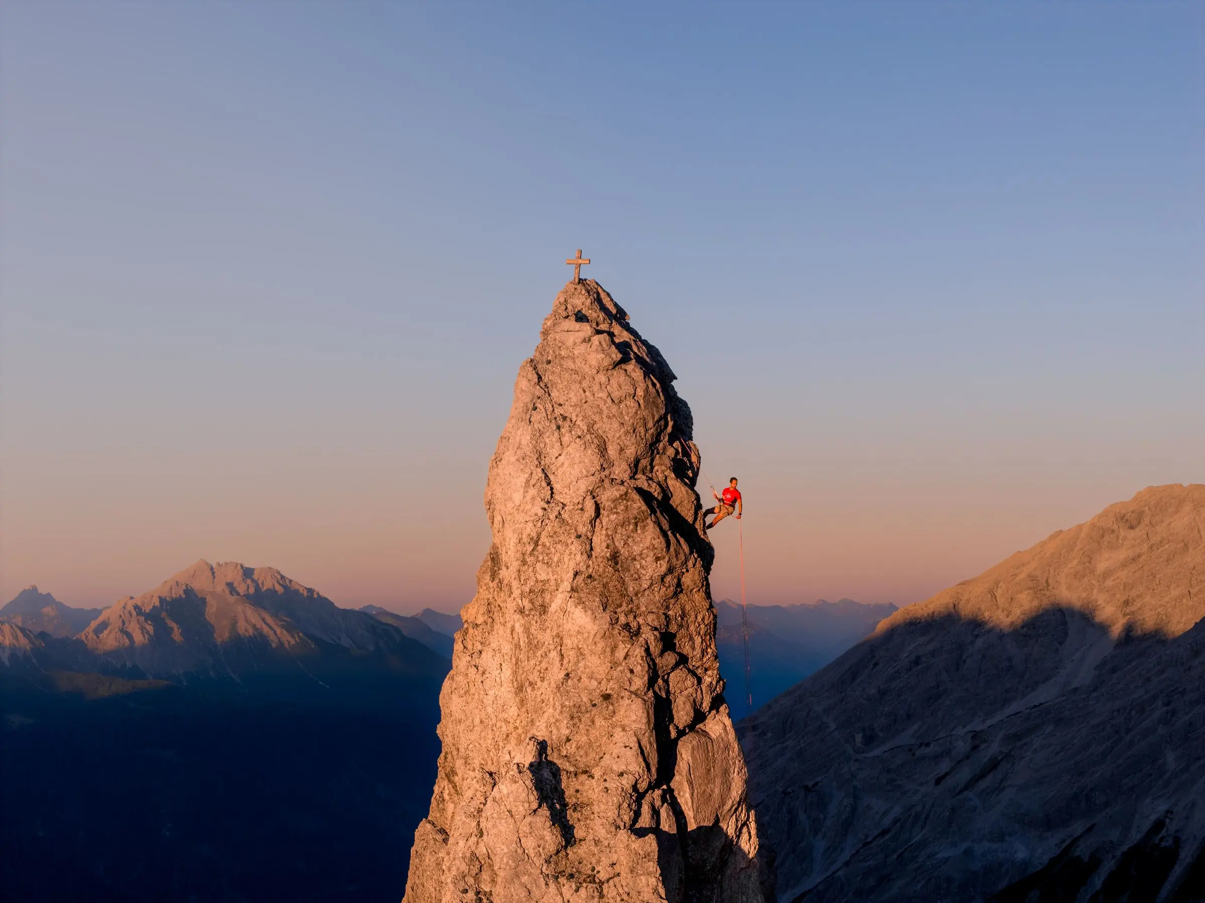 Beeindruckende Felsnadel als Luftaufnahme eines Kletterers beim abseilen - Actionsport Fotograf Kempten (Allgäu)