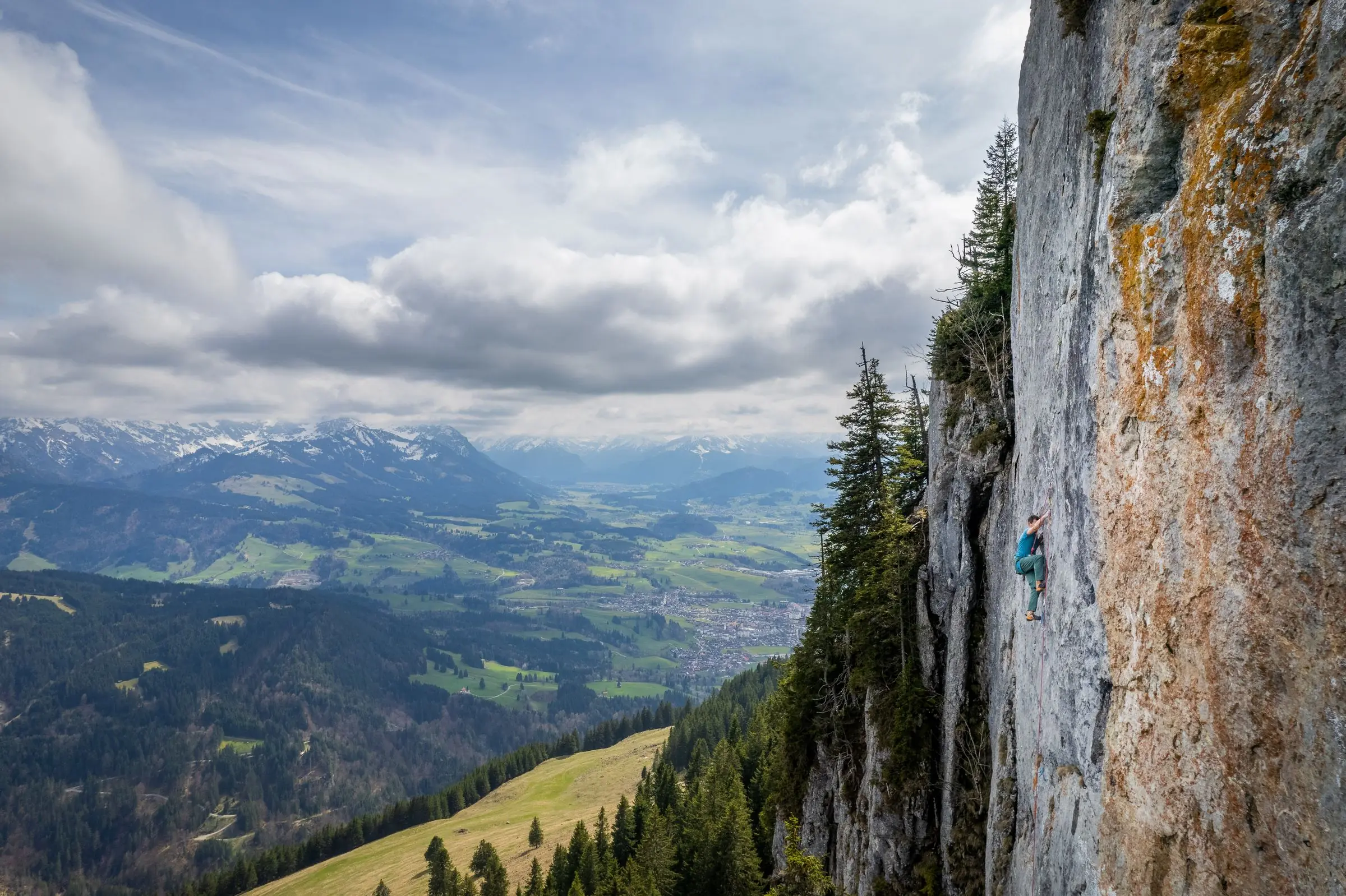Luftaufnahme Kletterer an Platte mit Blick auf Sonthofen im Frühling für DAV Kalender - Kletterfotograf Bayern Allgäu