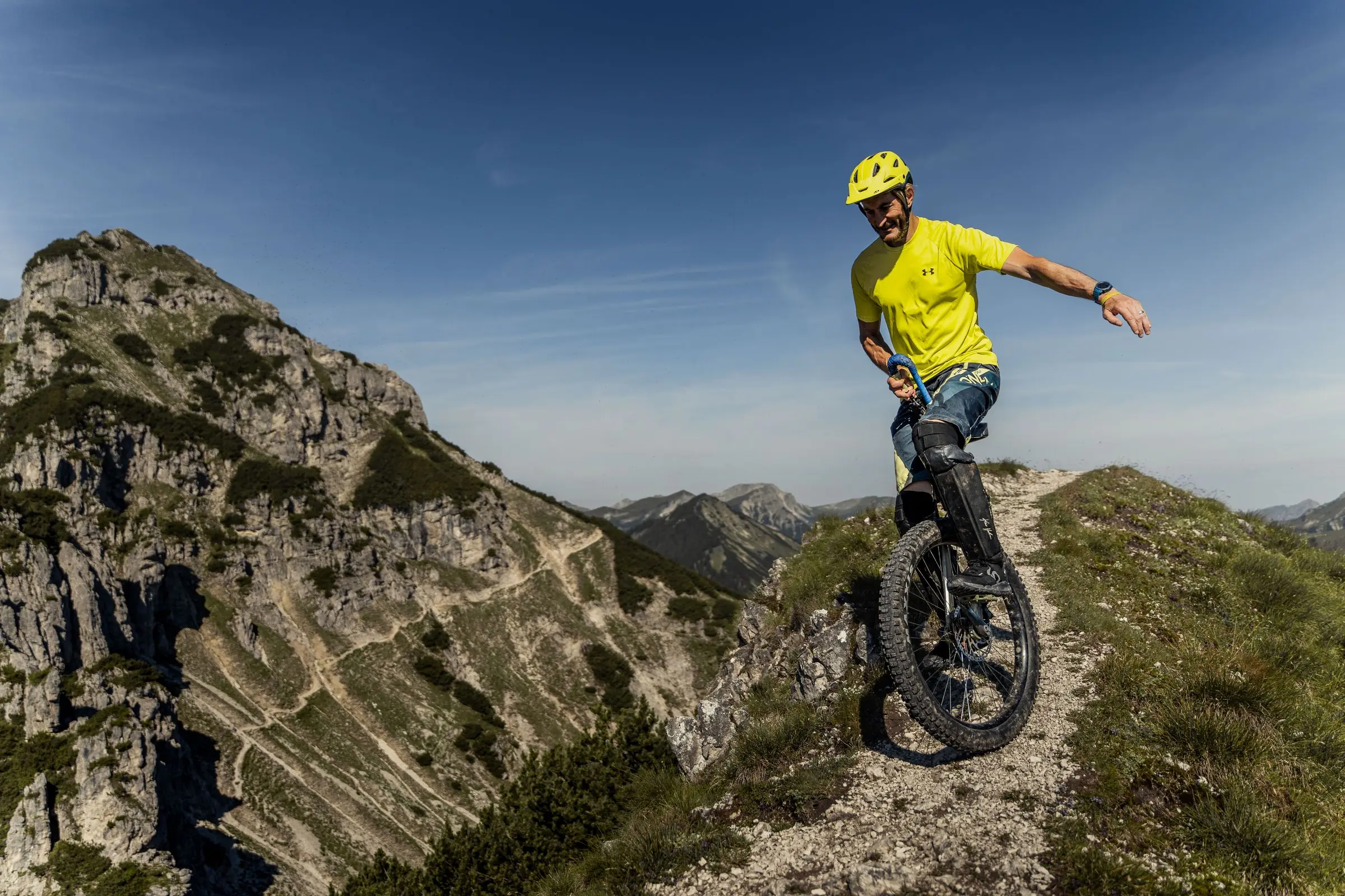 Muni-Fahrer in den Bergen mit Einrad actiongeladen downhill biken - Sportfotograf Alpen Bayern